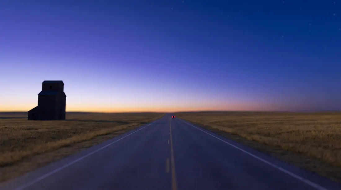 Prairie highway at blue hour with a grain elevator