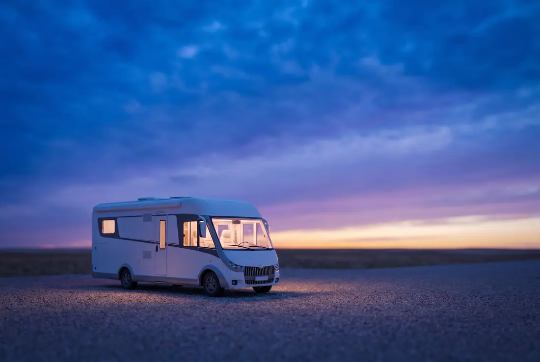 Motorhome parked on a gravel lot at dusk