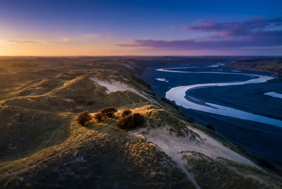 Sand hills above a winding river valley at dusk