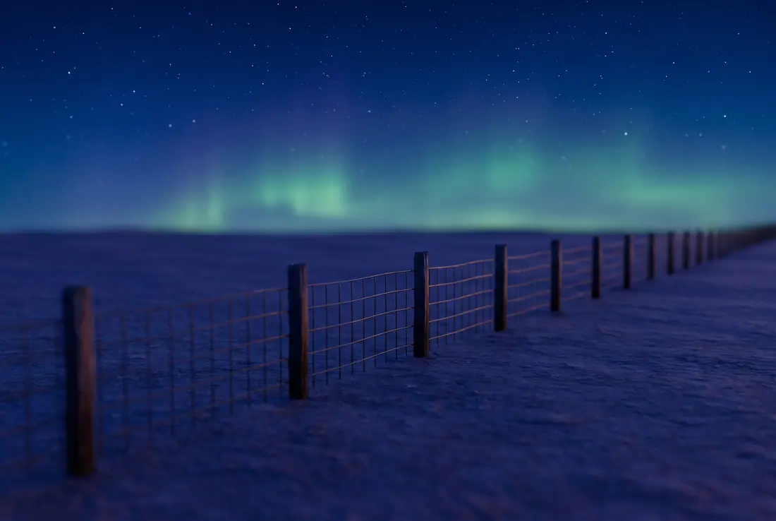 Starry sky with a faint aurora over flat prairie